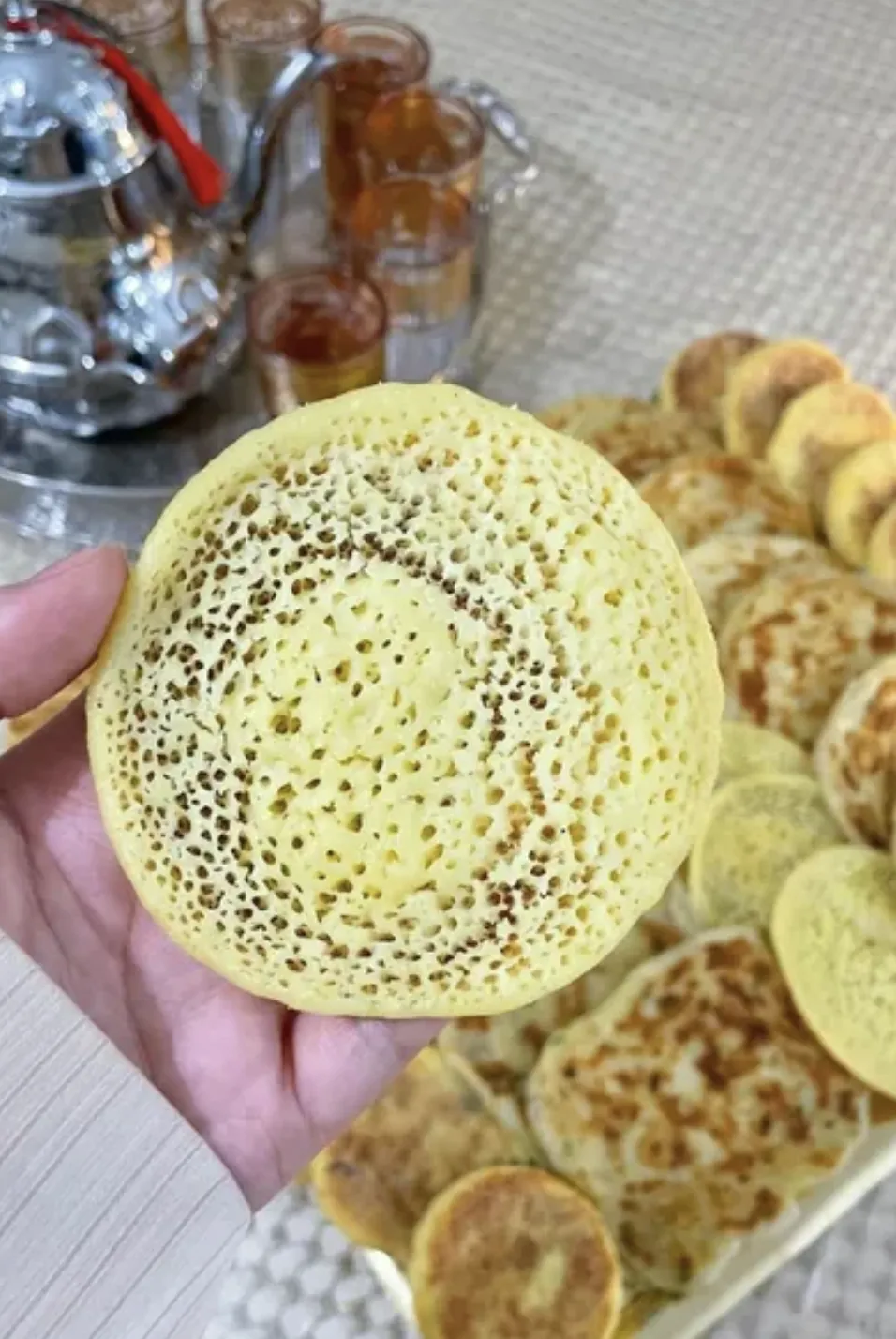 Baghrir moelleux aux petits trous, tenu à la main
