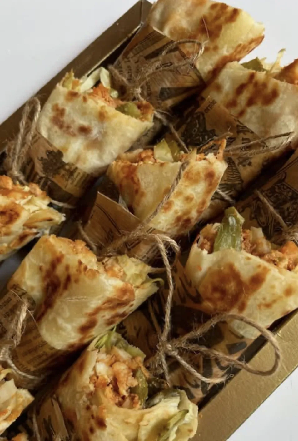 Assortiment de shawarma ficelés dans un plateau doré