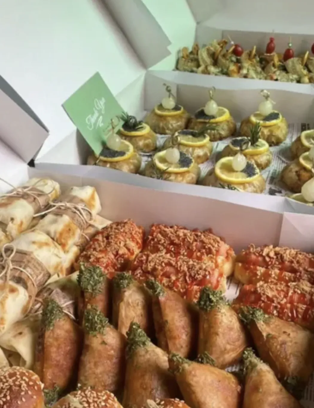 Plusieurs boîtes de commande remplies de canapés et feuilletés