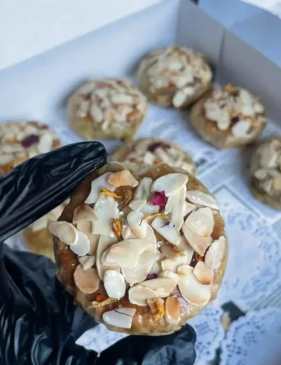 Pâtisserie aux amandes et fleurs tenue à la main