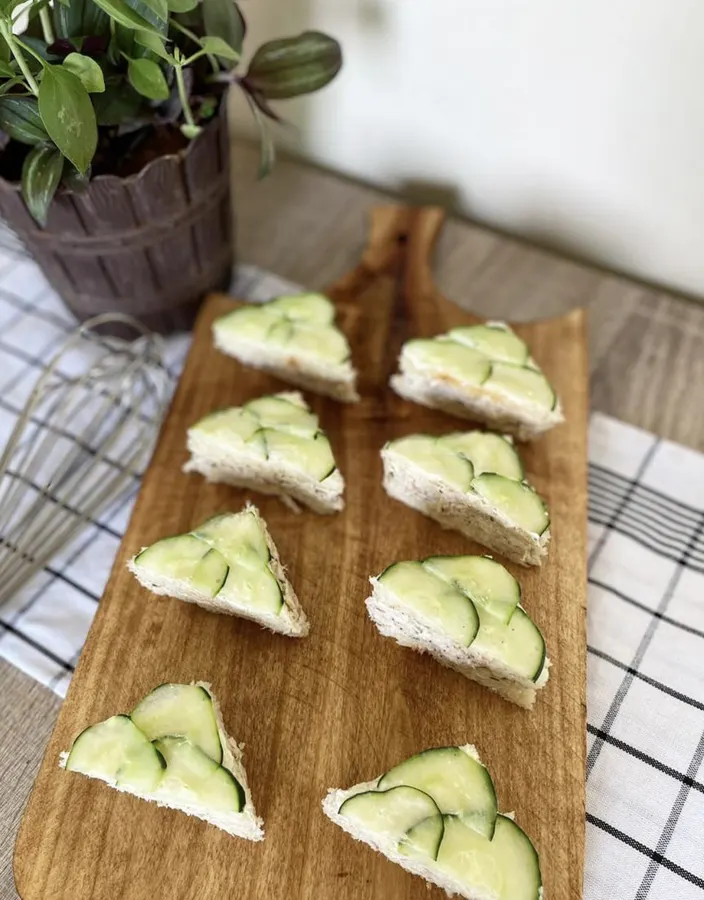 Huit mini sandwiches au thon et concombre sur la planche en bois