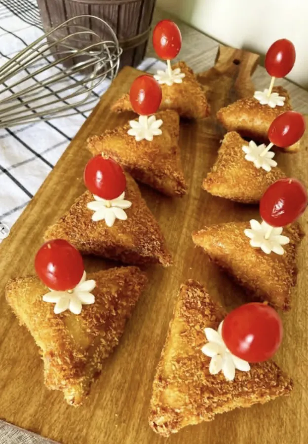 Huit mini crêpes dorées garnies de tomate cerise et fleur de fromage